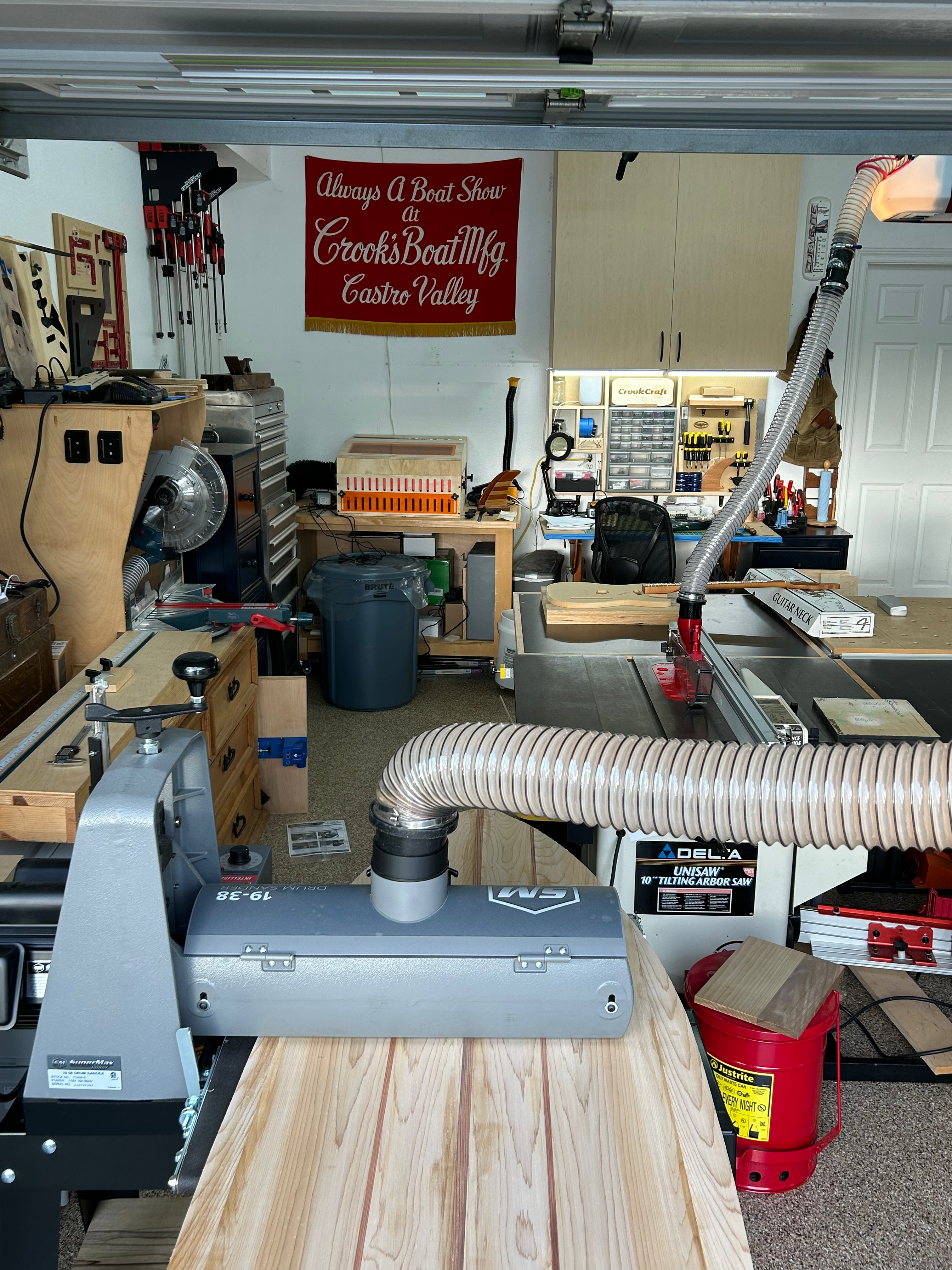 Drum sanding a surfboard in the shop